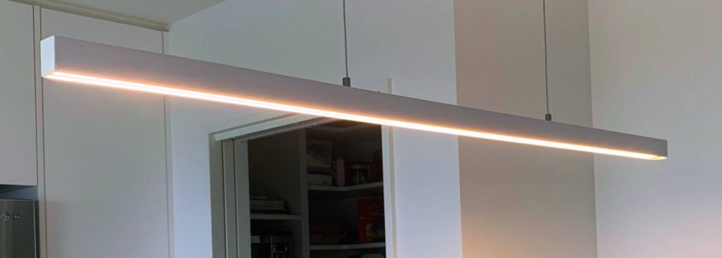Modern hanging LED bar light installed above kitchen island by Easy Electrical in Christchurch