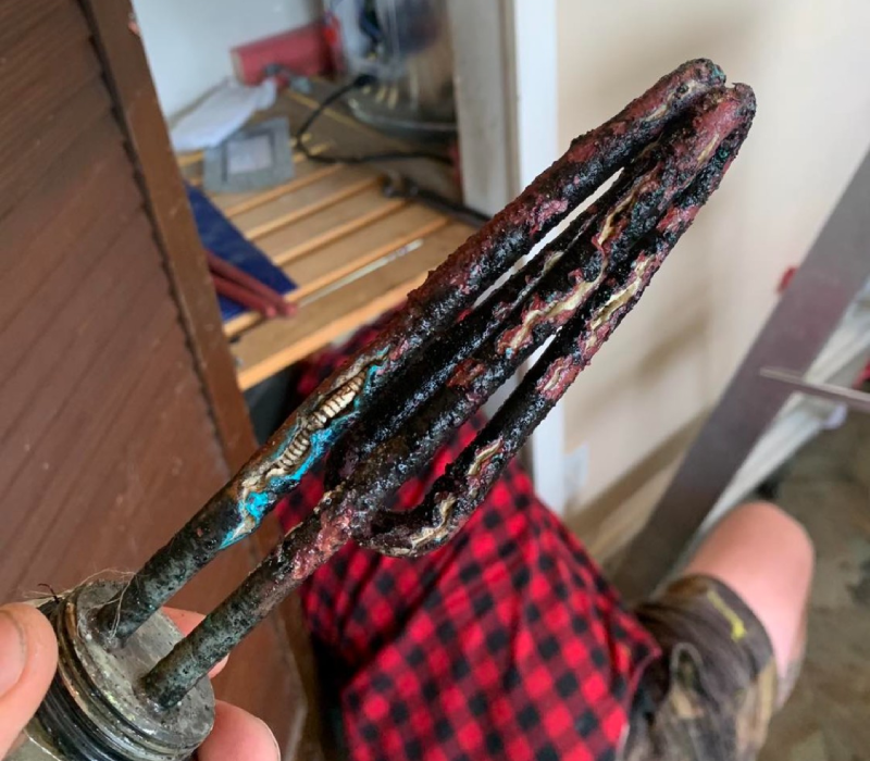 Old corroded hot water cylinder element removed during repair by Christchurch electrician.